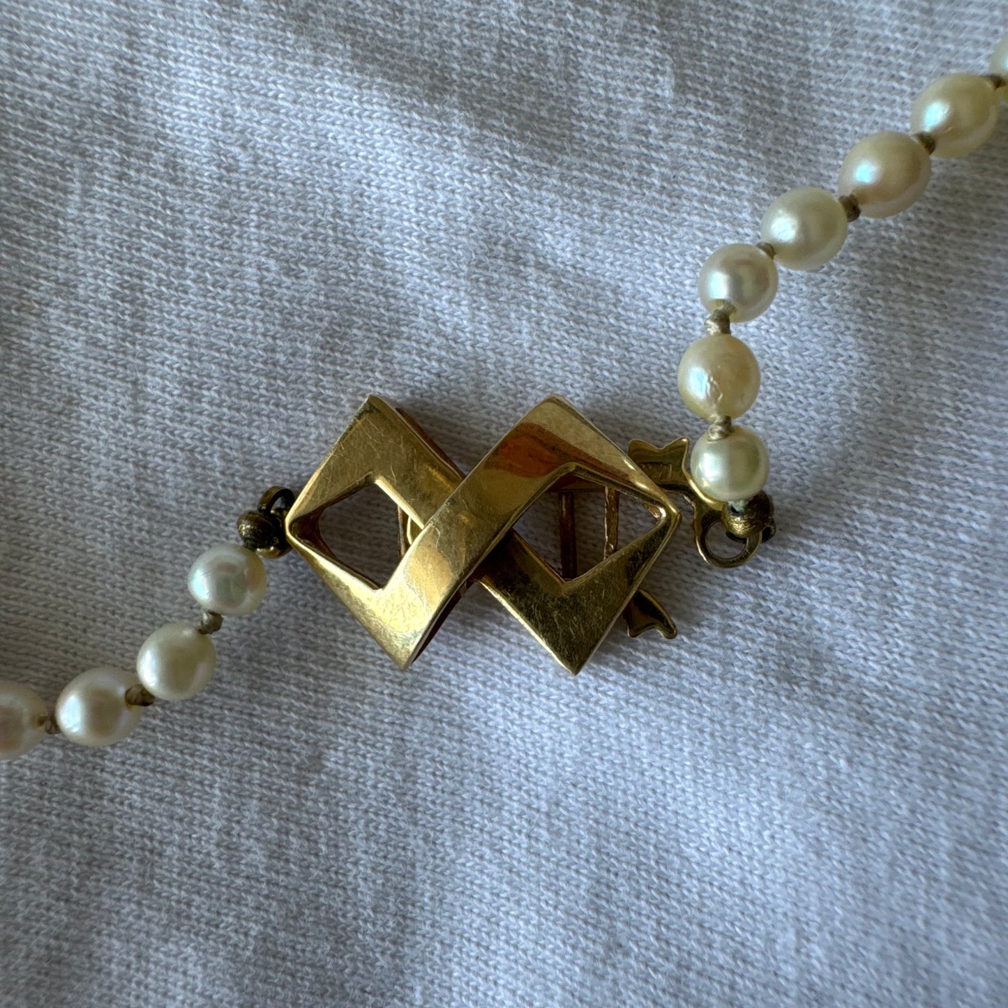 שרשרת פנינים קלאסית עם סוגר גאומטרי מזהב צהוב 14 קראט.