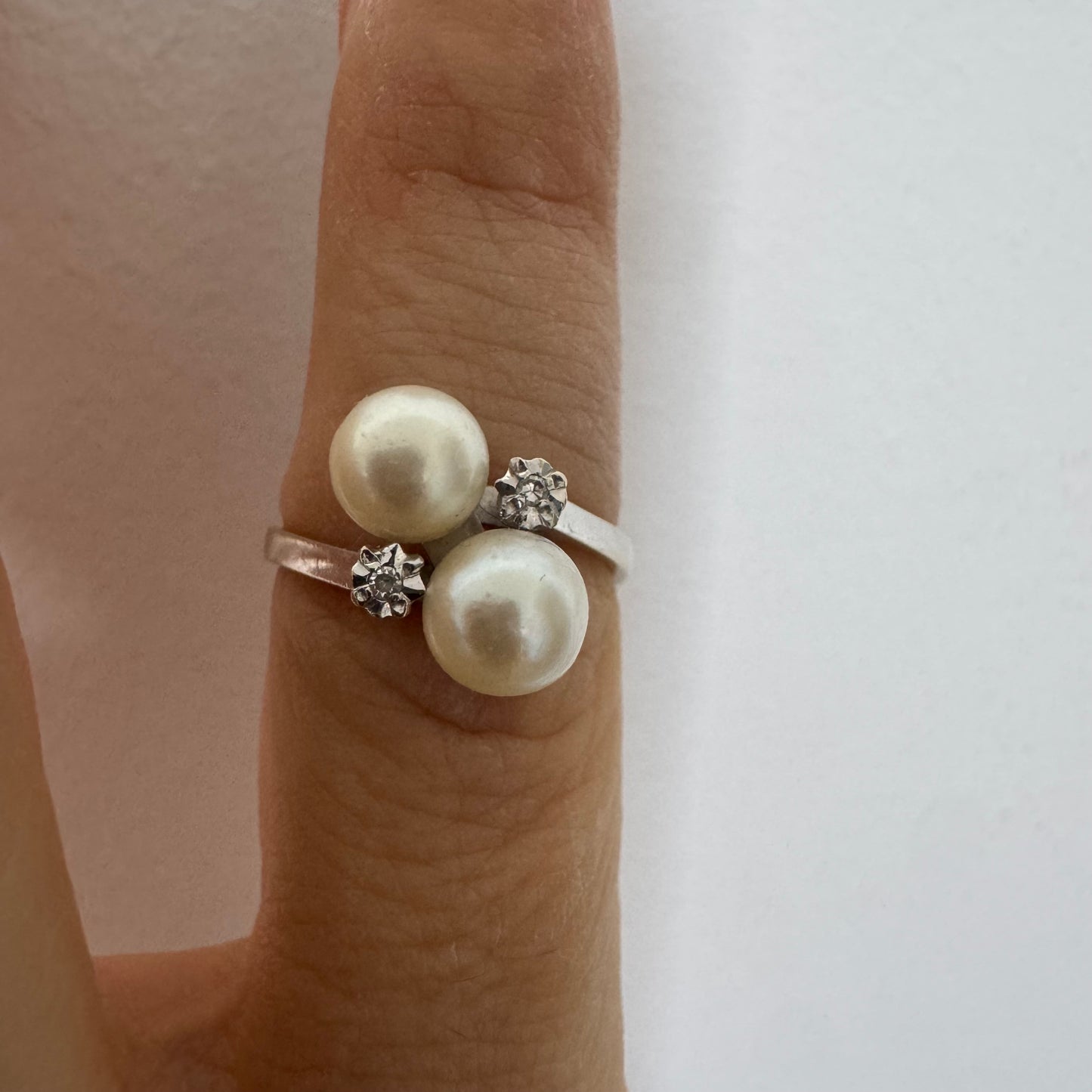 18K gold ring featuring a refined open design set with two luminous white Pearls and accented with two sparkling Diamonds