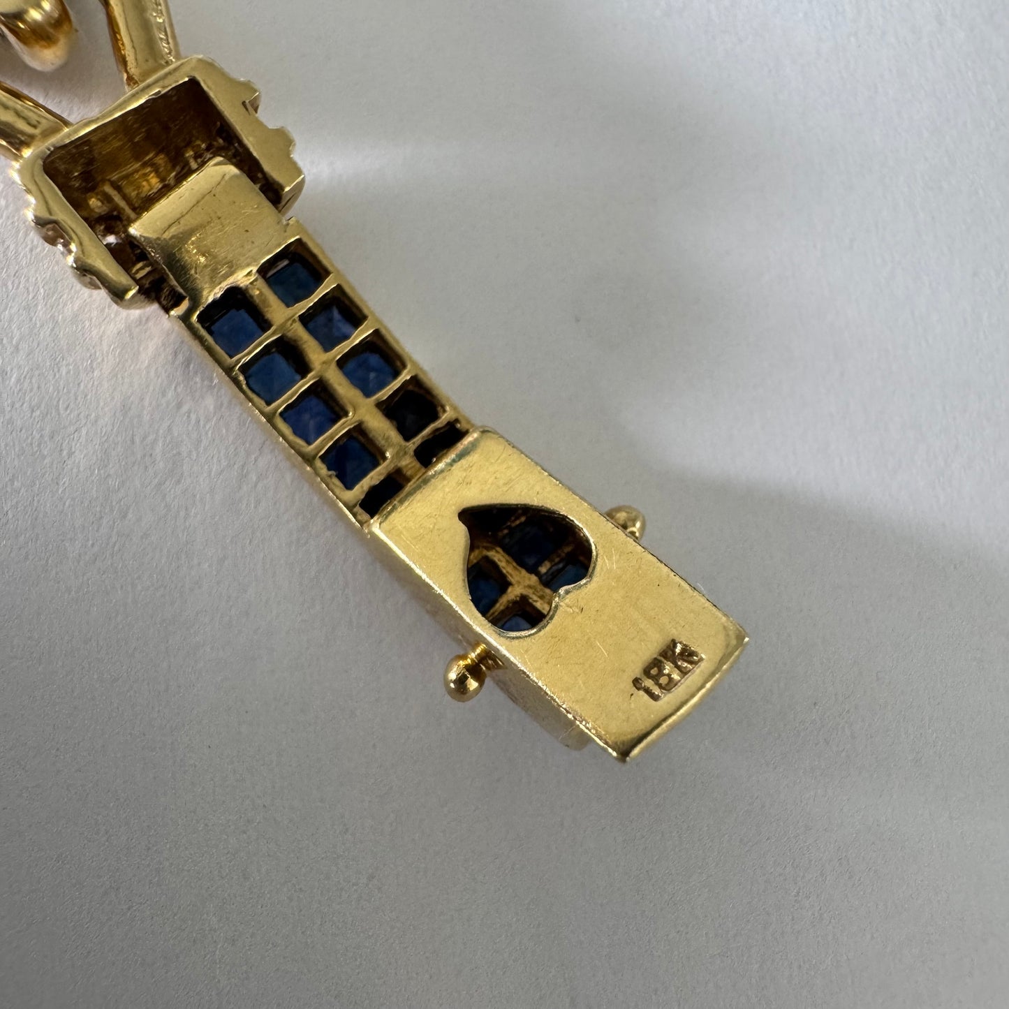 18K gold bracelet featuring a bold link design set with deep blue Sapphires and a subtle Diamond accent at the center.