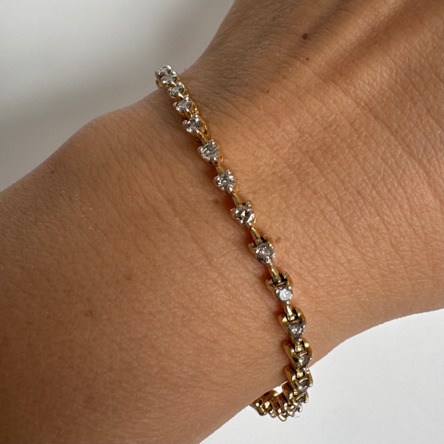 צמיד טניס מזהב צהוב 14 קראט משובץ שורת יהלומים, היוצרים ברק רציף ומראה נקי ועל-זמני.