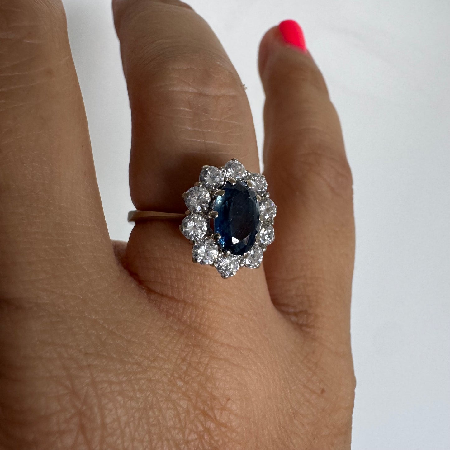 18K gold ring featuring a deep blue Sapphire at its center, surrounded by a sparkling halo of Diamonds
