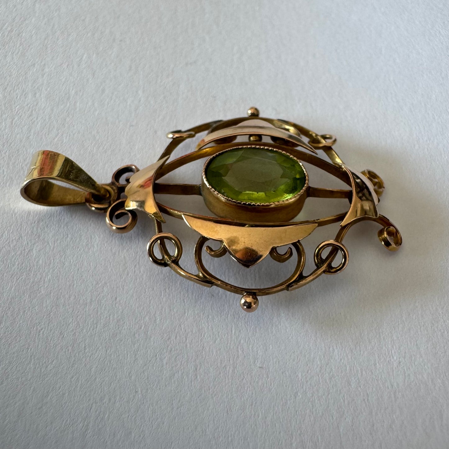 9K gold pendant featuring an oval-cut Peridot in a vibrant green hue.