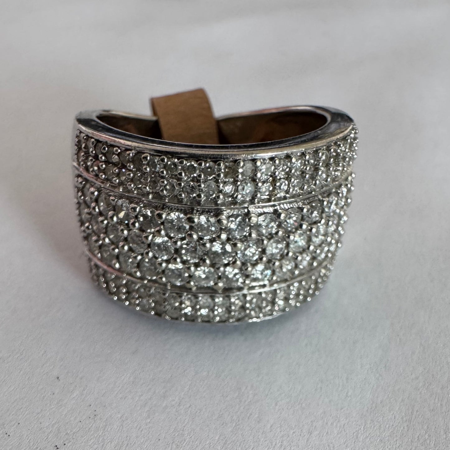 טבעת זהב לבן 18 קראט בעיצוב רחב ומרשים, משובצת יהלומים בשיבוץ פאווה צפוף המעניק ברק עשיר ונוכחות יוקרתית מכל זווית.