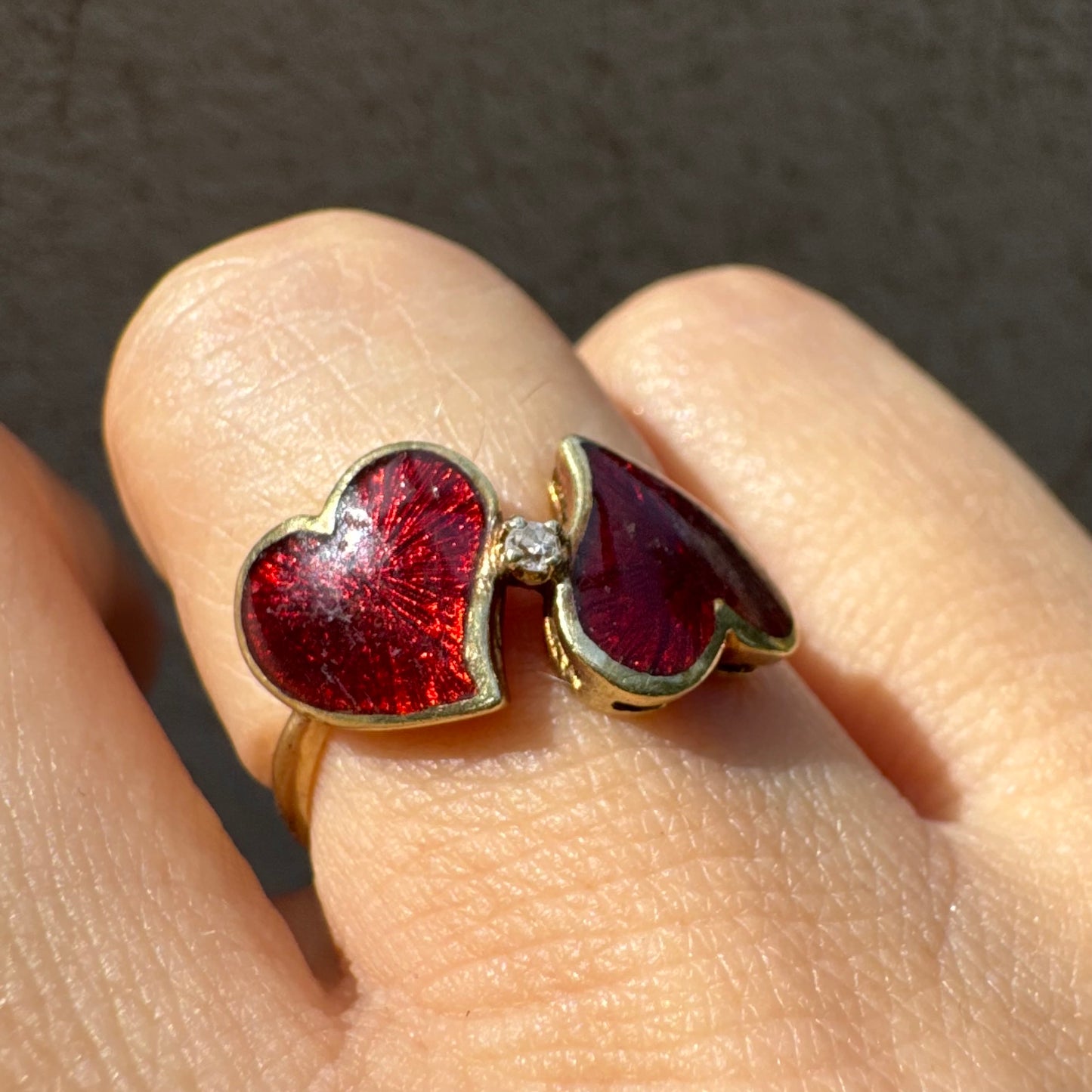 טבעת זהב צהוב 14 קראט “שני לבבות מחוברים״ מצופים אמייל אדום ויהלום משובץ במרכז