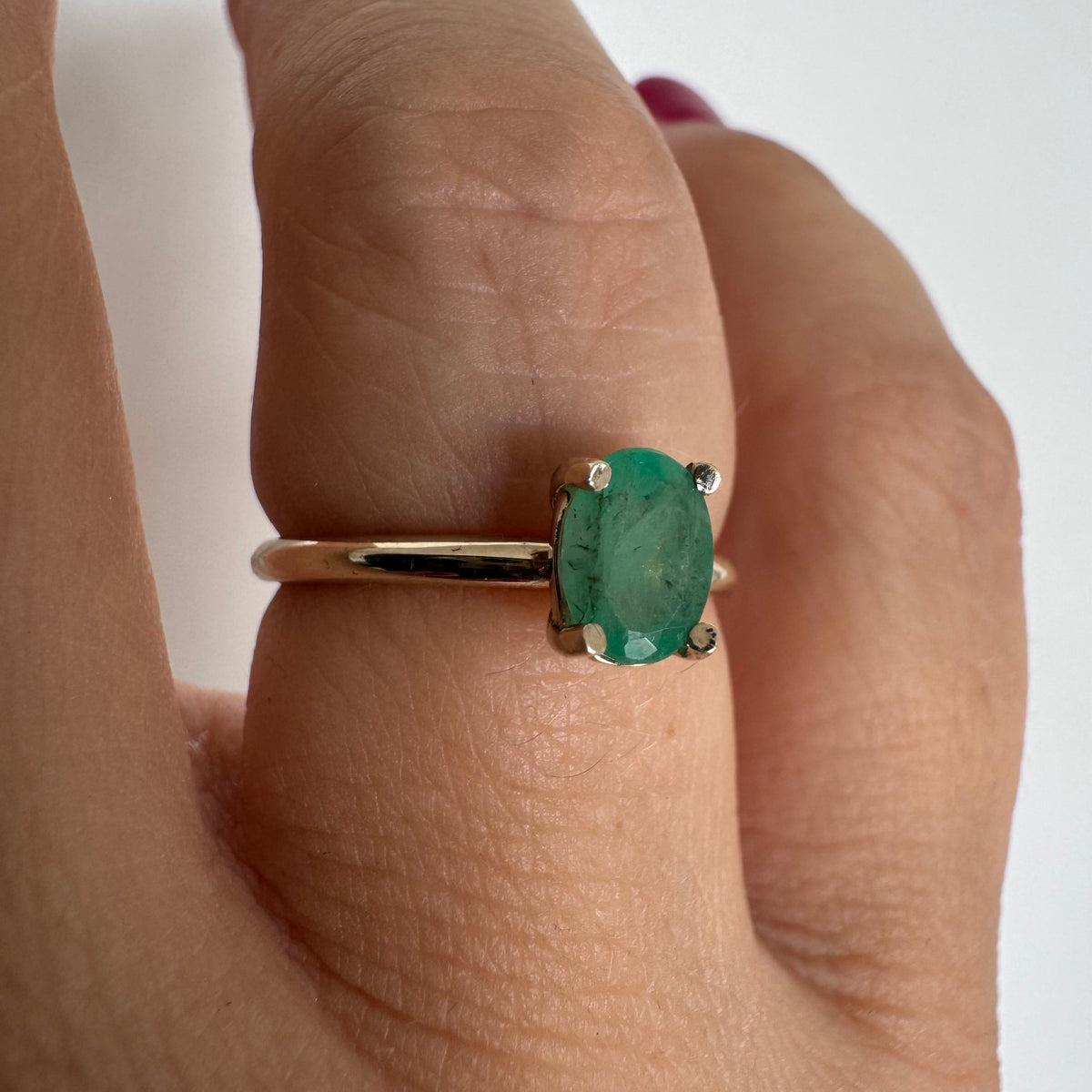 14K gold ring set with an oval-cut Emerald