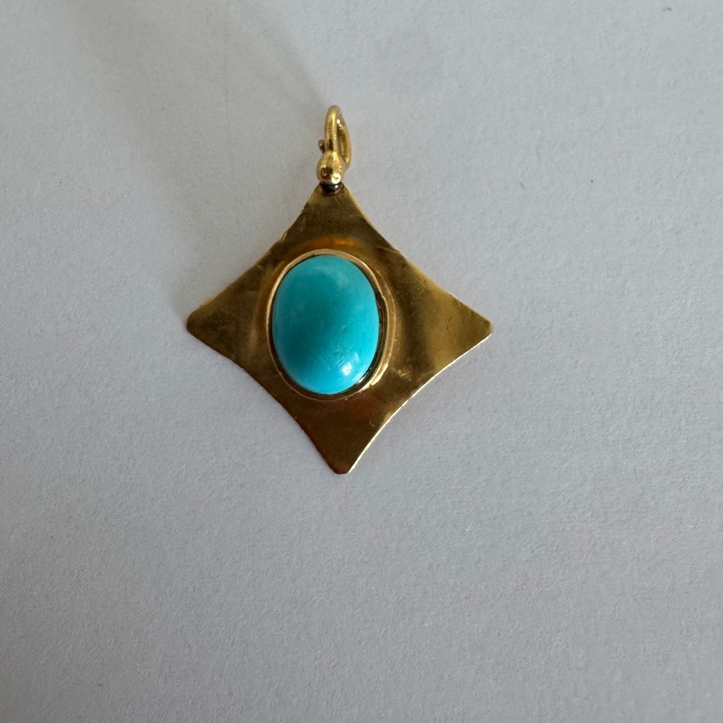 18K gold pendant set with a vibrant Turquoise stone in a bold, geometric design.
