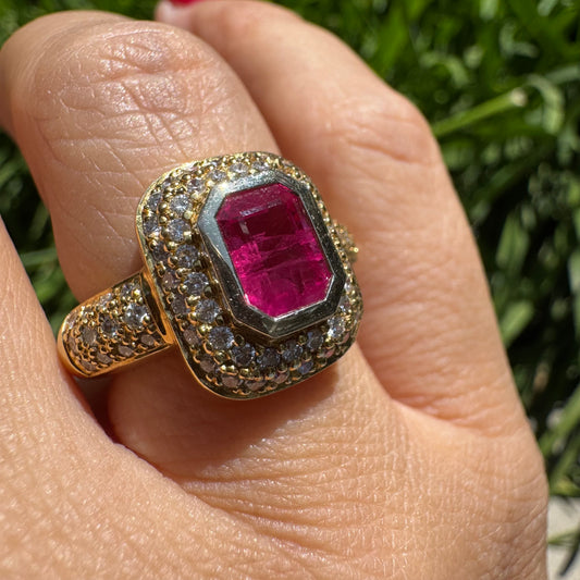18K gold ring set with a bold octagon-cut Ruby surrounded by two halos of sparkling Diamonds.