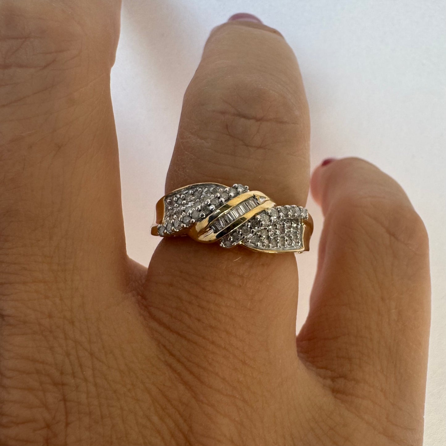 10K gold ring set with round-cut Diamonds and a central row of baguette Diamonds.