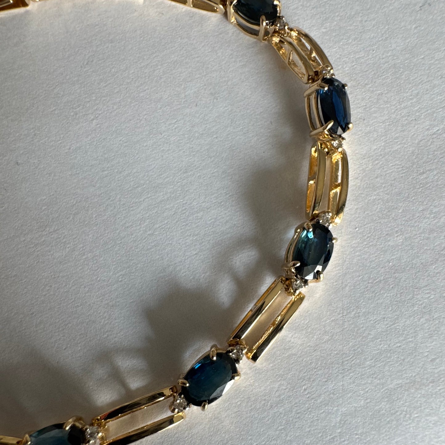 צמיד זהב צהוב 14 קראט משובץ אבני טופז כחולות בחיתוך אובלי, עם יהלומים המשובצים ביניהן להוספת ברק עדין.