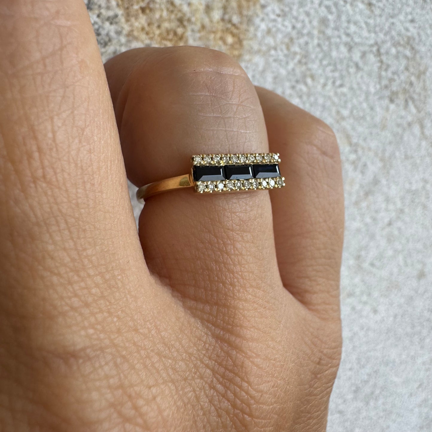 14K gold ring set with baguette-cut Sapphire framed by sparkling Diamonds