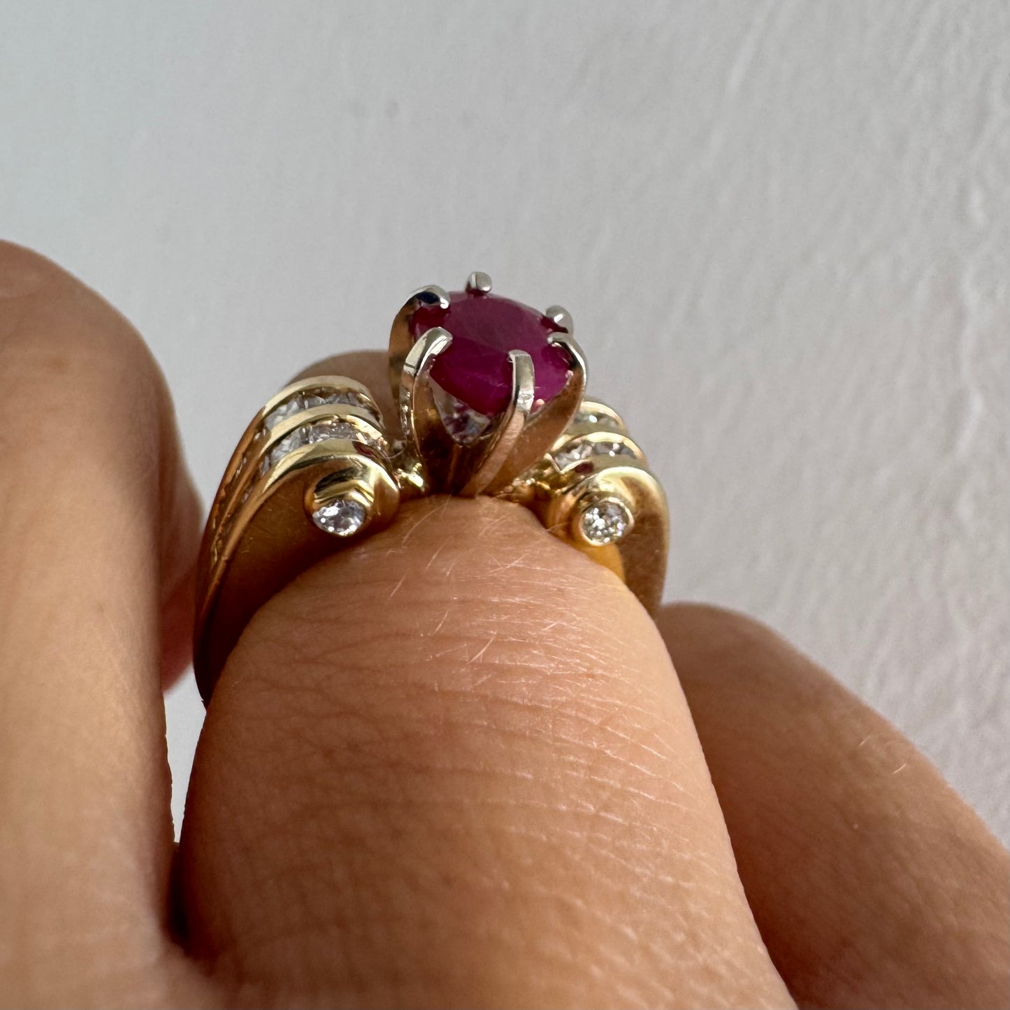 14K gold ring set with a vivid natural Ruby at the center and accented by rows of Diamonds on both sides.
