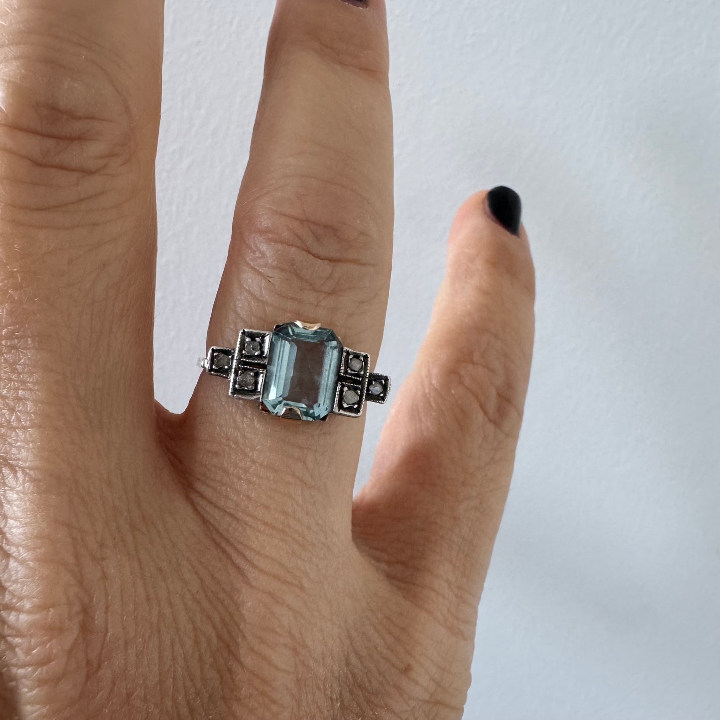 טבעת עתיקה מזהב 14 קראט, משובצת אבן אקוומרין מרכזית בחיתוך מלבני ויהלומים.