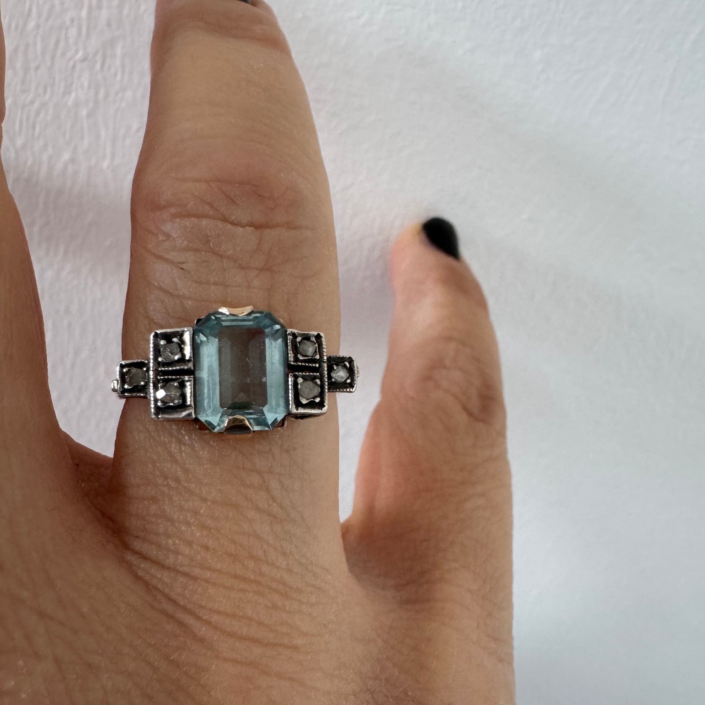 טבעת עתיקה מזהב 14 קראט, משובצת אבן אקוומרין מרכזית בחיתוך מלבני ויהלומים.