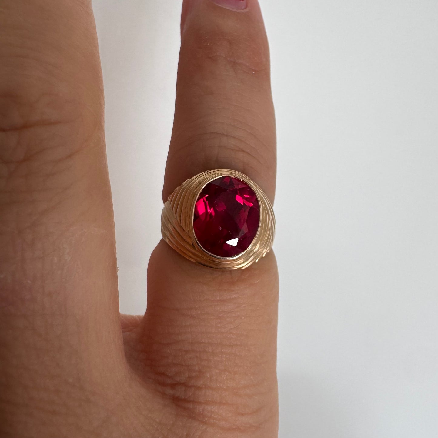 18K gold ring set with a striking oval-cut Ruby gemstone.