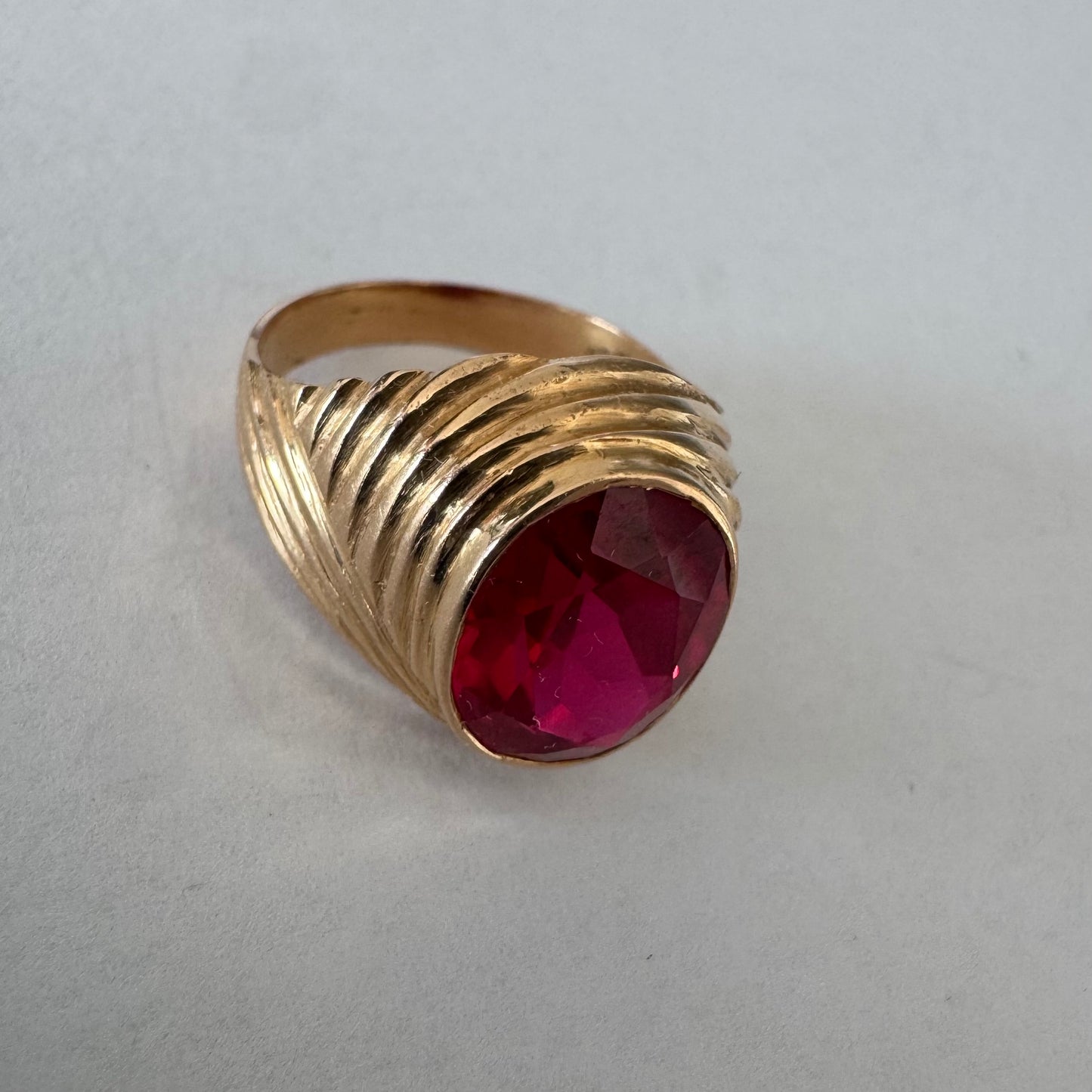 18K gold ring set with a striking oval-cut Ruby gemstone.