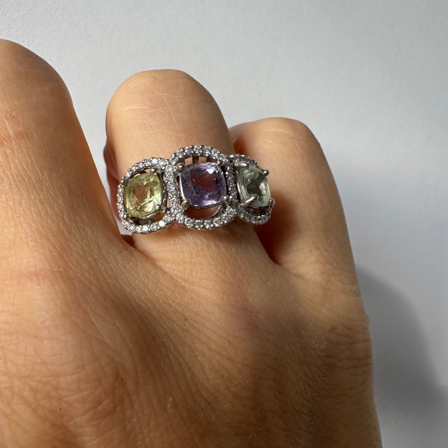 18K gold ring set with three pastel gemstones in soft shades of lilac, yellow and light gray