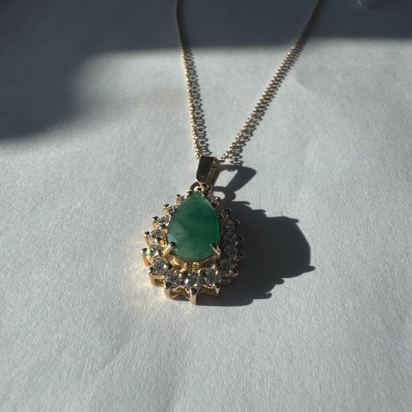 14K gold necklace set with a pear-cut Emerald, surrounded by sparkling lab-grown Diamonds.