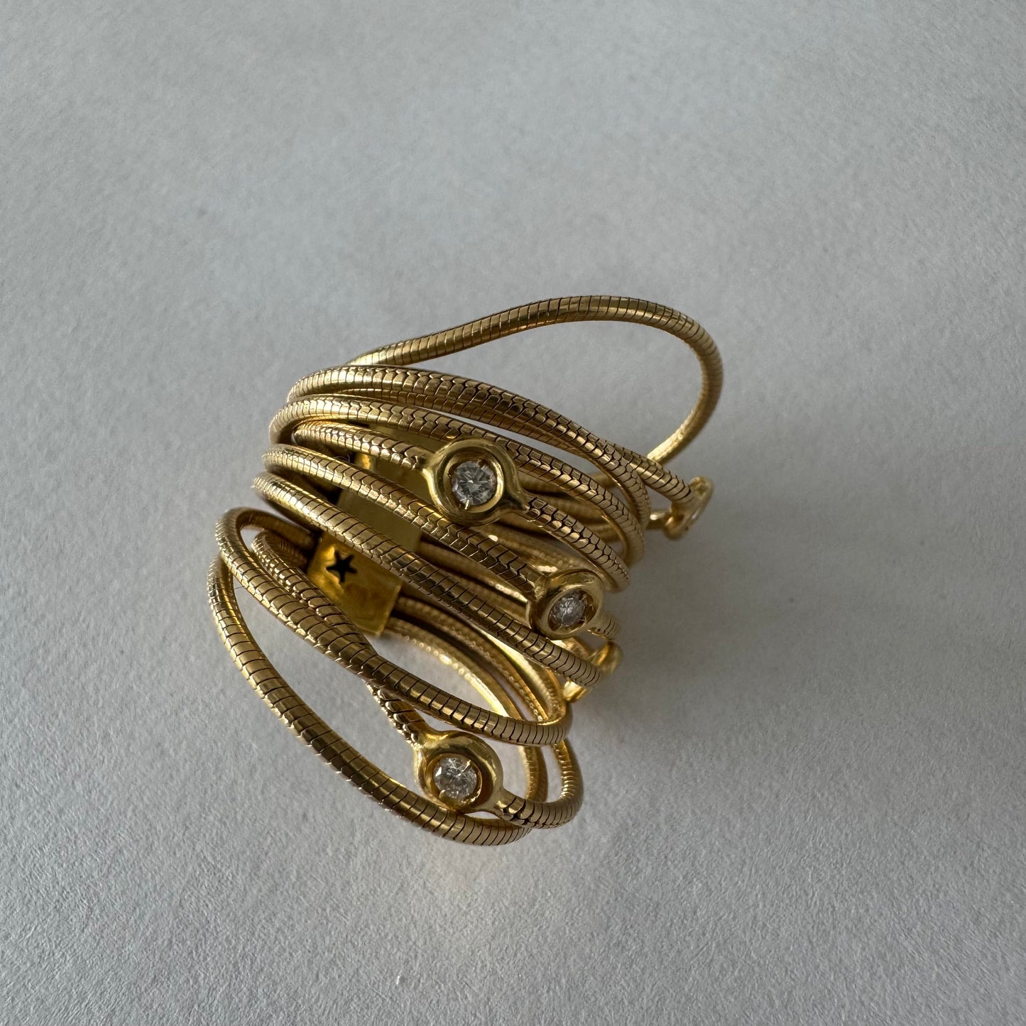 טבעת זהב צהוב 18 קראט של המותג H. Stern משובצת יהלומים בעיצוב רב־ליפופים אלגנטי 