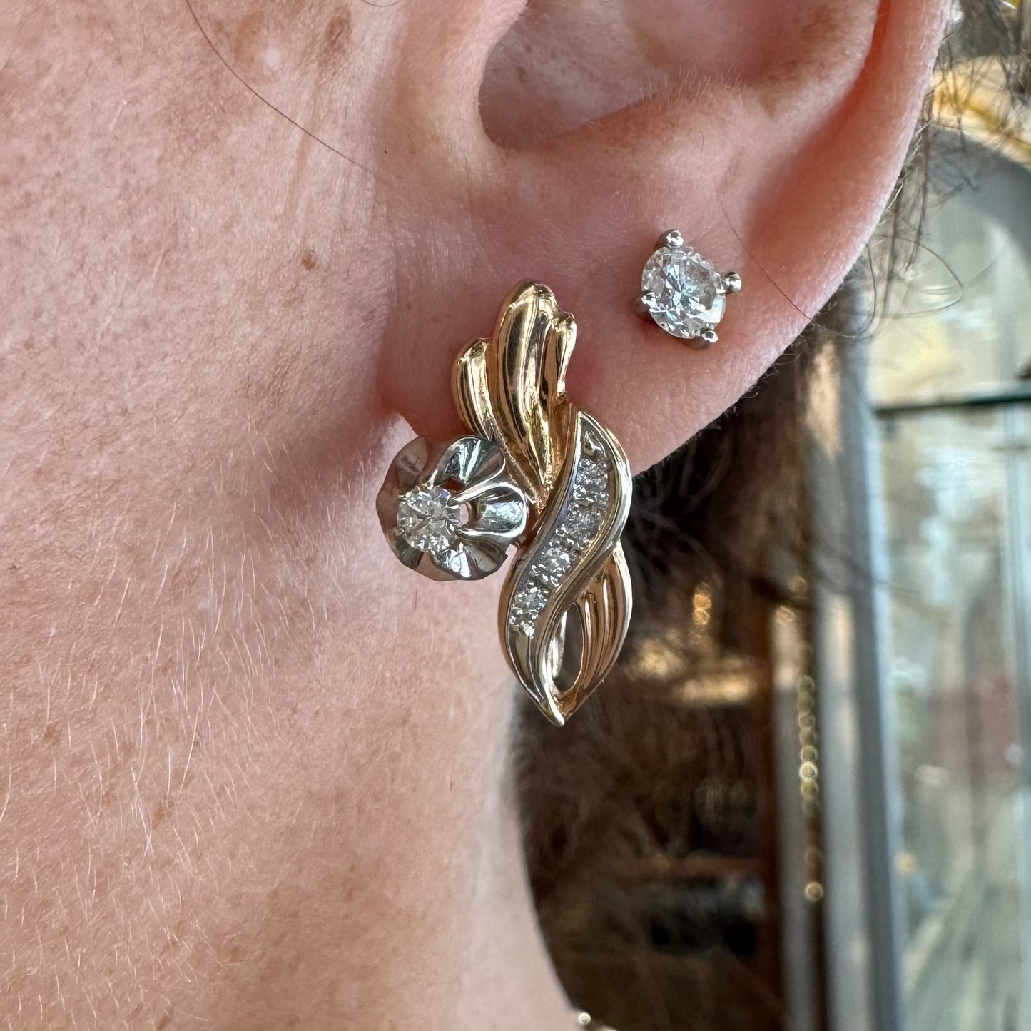 עגילי זהב 14 קראט בעיצוב מתעגל ואלגנטי המשובצים יהלומים נוצצים .