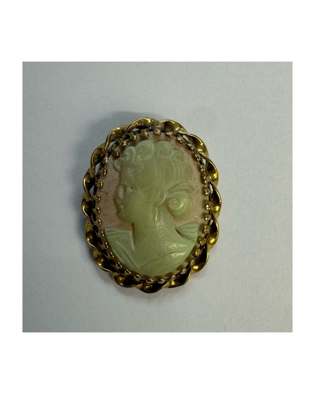 14K gold vintage cameo brooch featuring a hand-carved figure in a soft green tone, set in a classic decorative gold frame.
