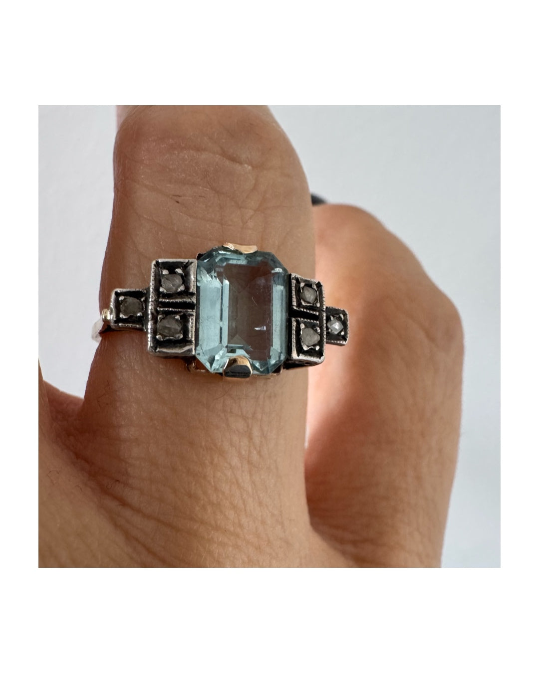 טבעת עתיקה מזהב 14 קראט, משובצת אבן אקוומרין מרכזית בחיתוך מלבני ויהלומים.