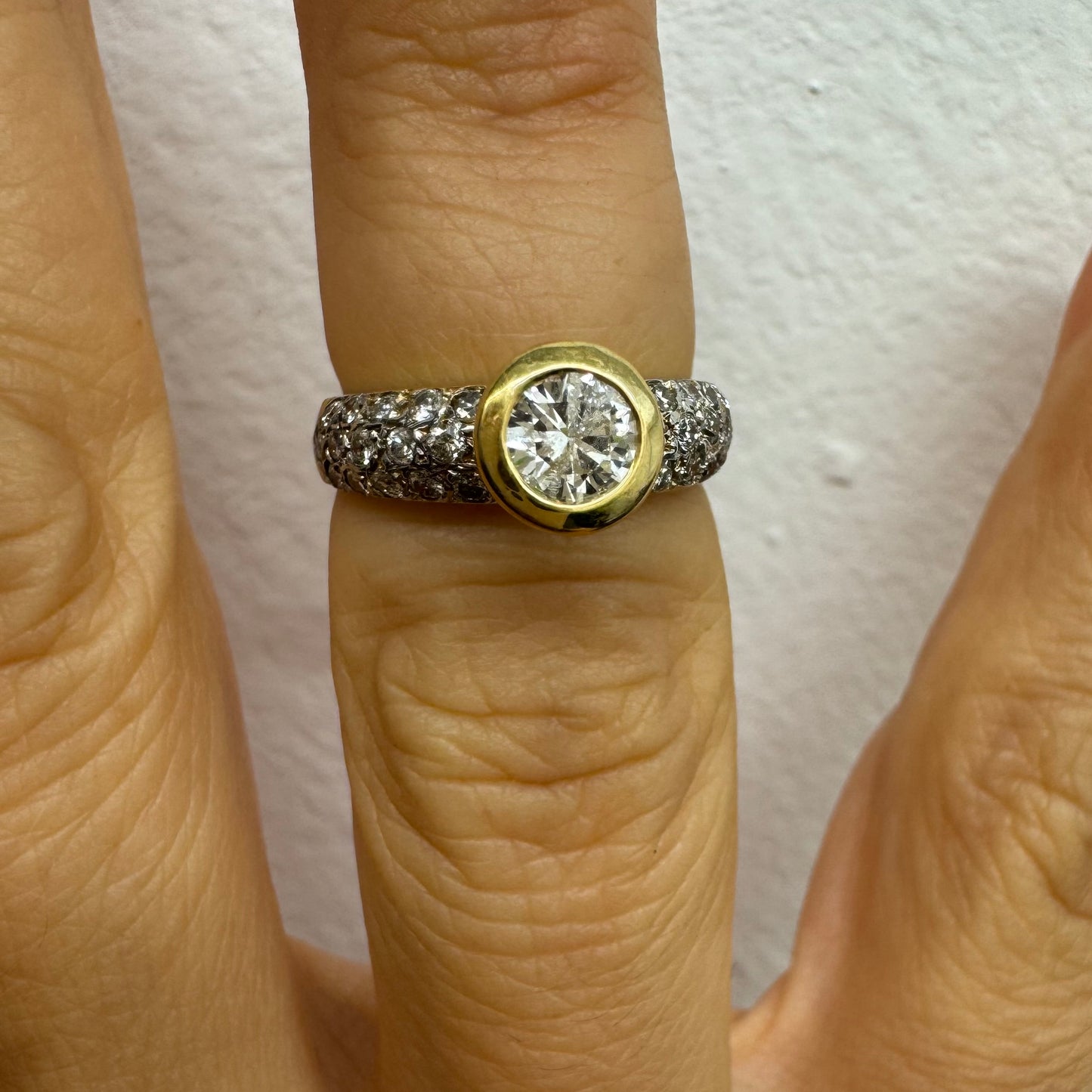 טבעת זהב צהוב 14 קראט משובצת יהלום עגול ויהלומים נוספים על הרצועה.