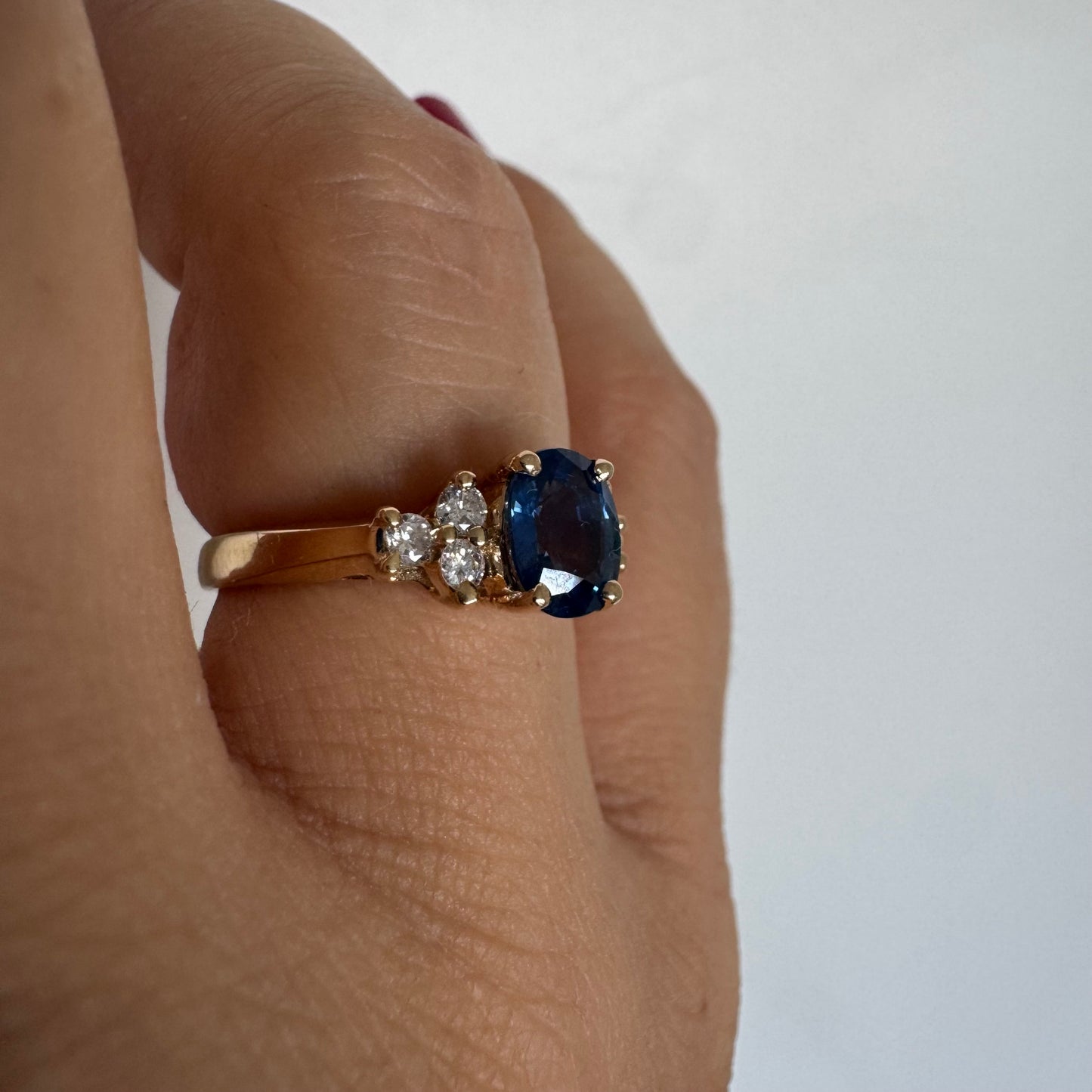 14K gold ring set with an oval blue Sapphire at the center & Diamonds