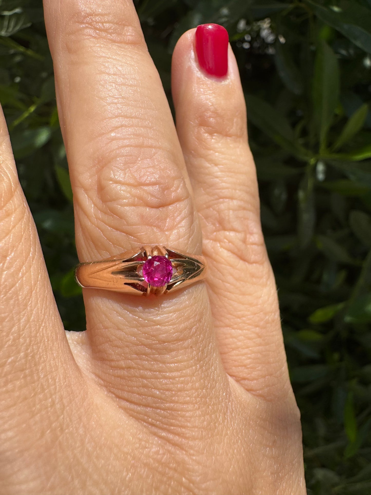 14K gold ring set with a vivid pink round-cut Ruby