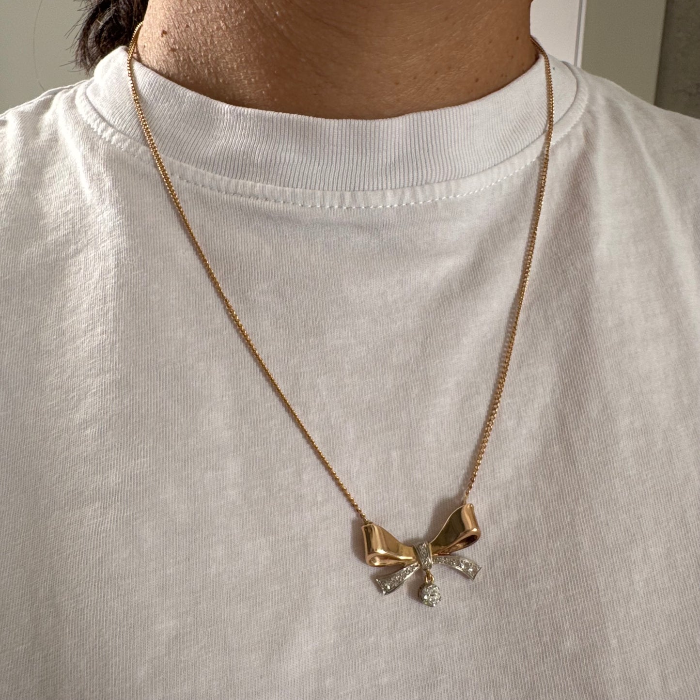 שרשרת זהב 18 קראט עם תליון בצורת סרט קלאסי משובץ יהלומים ונושא יהלום מרכזי תלוי שמוסיף נגיעה של זוהר ואלגנטיות