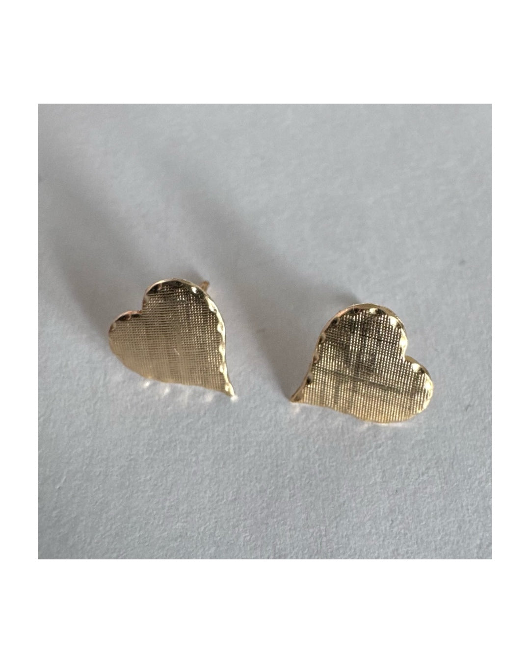 עגילי זהב צהוב 10 קראט בצורת לב, עם טקסטורה עדינה וגימור רך.