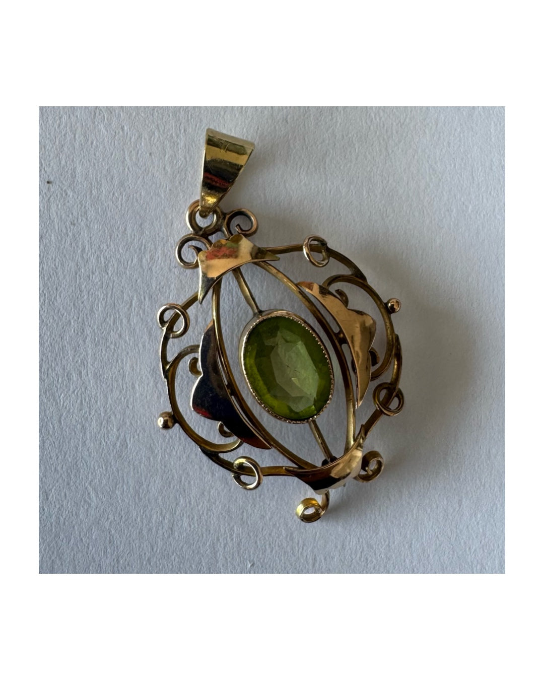 9K gold pendant featuring an oval-cut Peridot in a vibrant green hue.