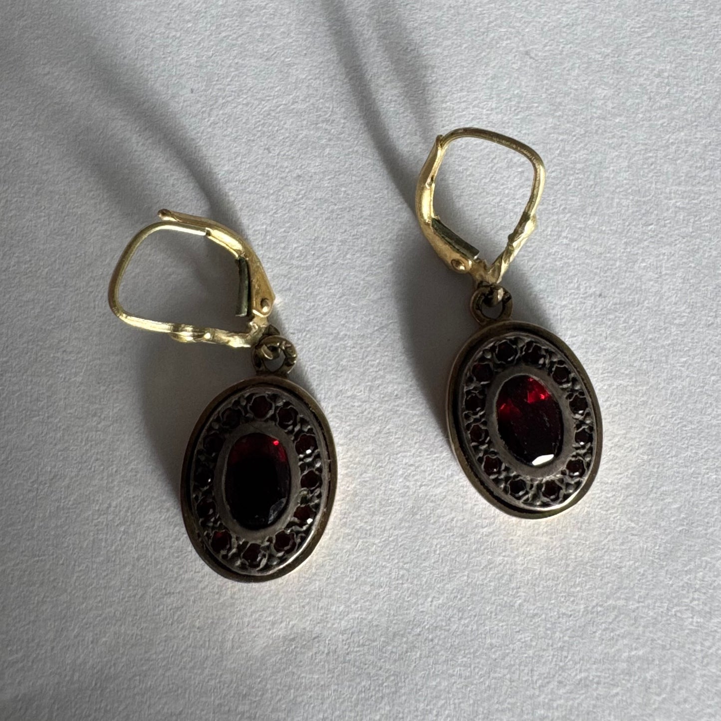 14K gold drop earrings set with deep red oval Garnets surrounded by smaller stones Garnets.