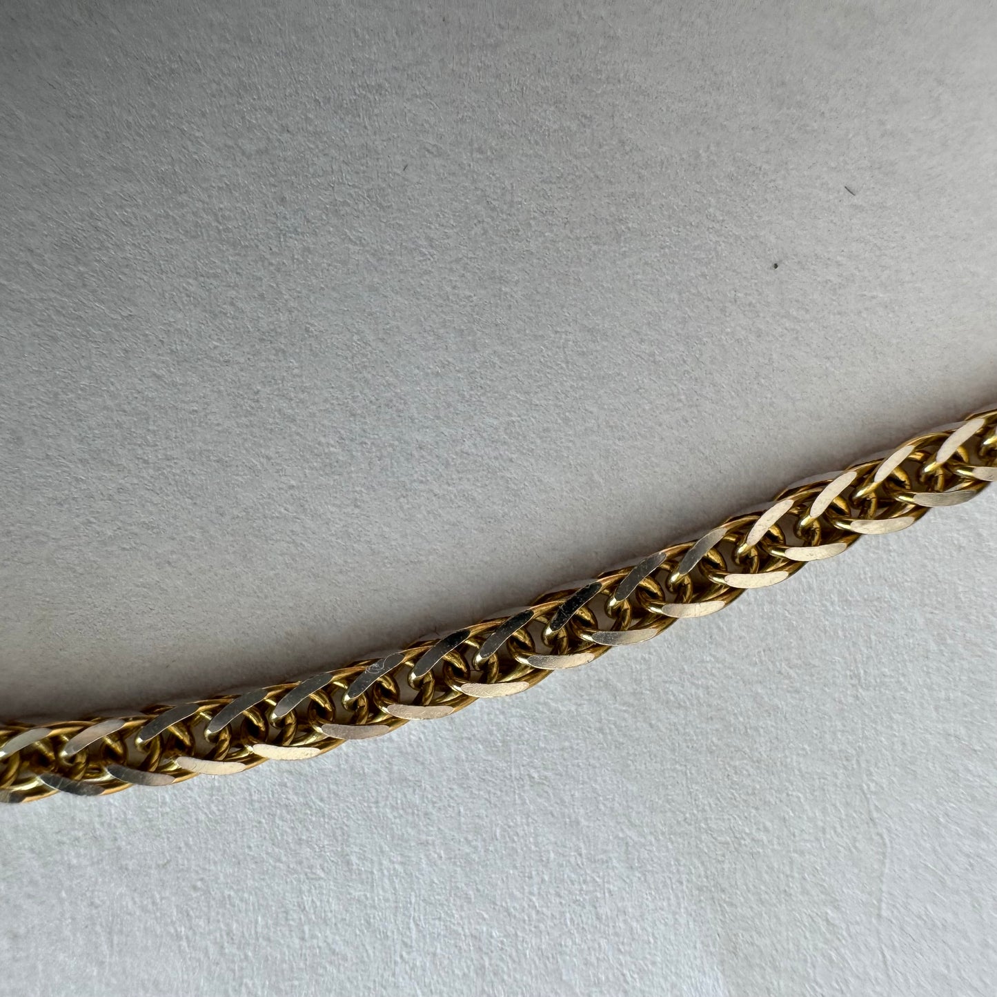 שרשרת זהב צהוב 14 קראט בעיצוב חוליות קלועות היוצרות מראה עשיר ומלא ברק.