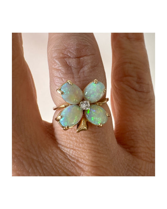 טבעת זהב 14 קראט בעיצוב פרח, משובצת ארבע אבני אופל בחיתוך טיפה ובמרכז יהלום טבעי.