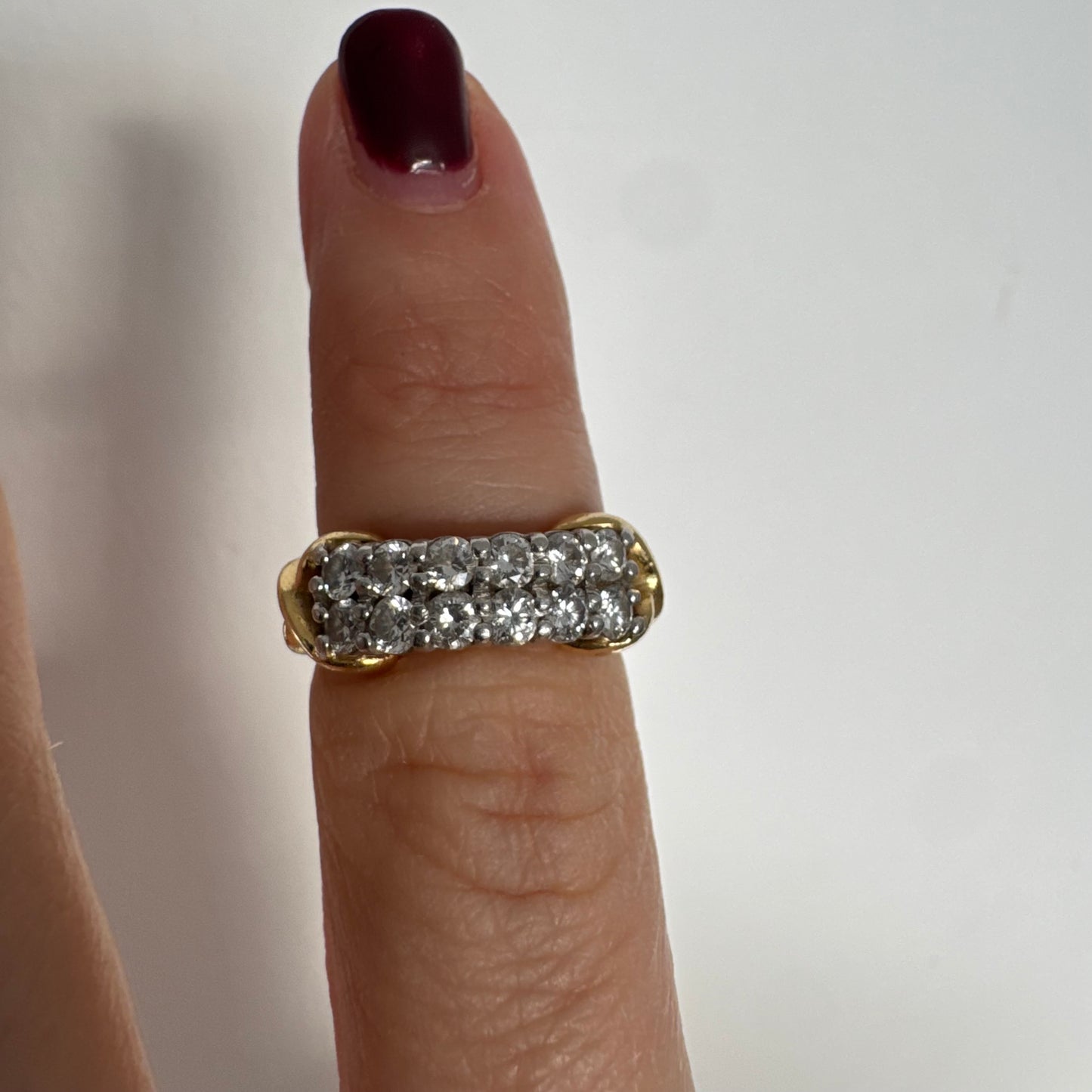 טבעת זהב צהוב 18 קראט משובצת יהלומים עגולים בשתי שורות צפופות, במבנה מלבני מעוגל.