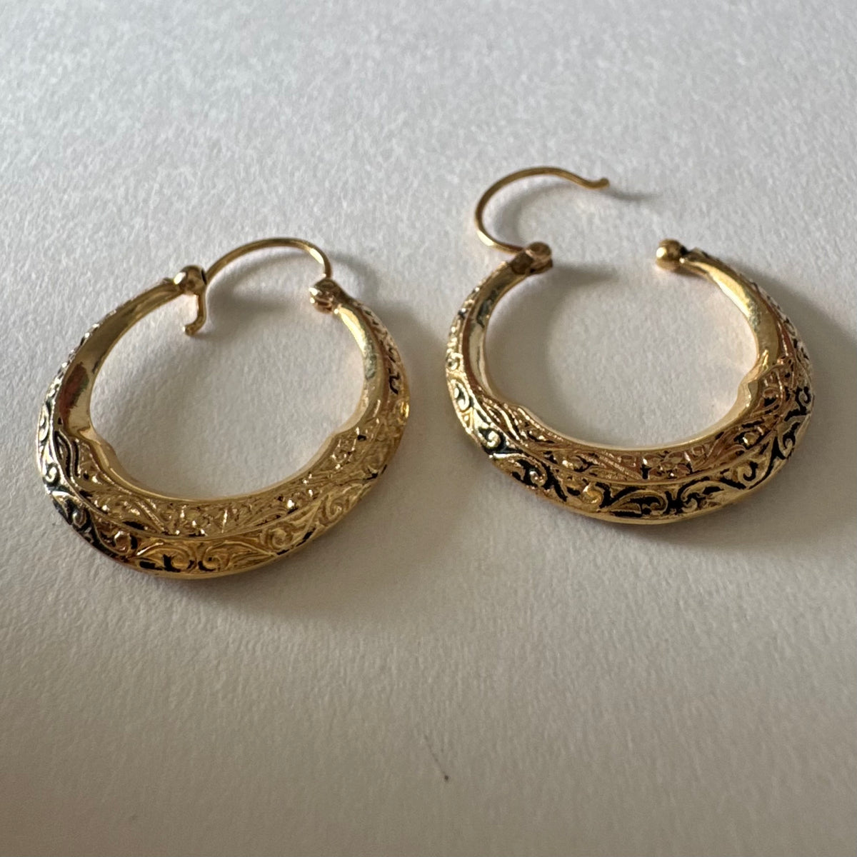 14K gold hoop earrings featuring an intricate openwork design and beautifully detailed engraving
