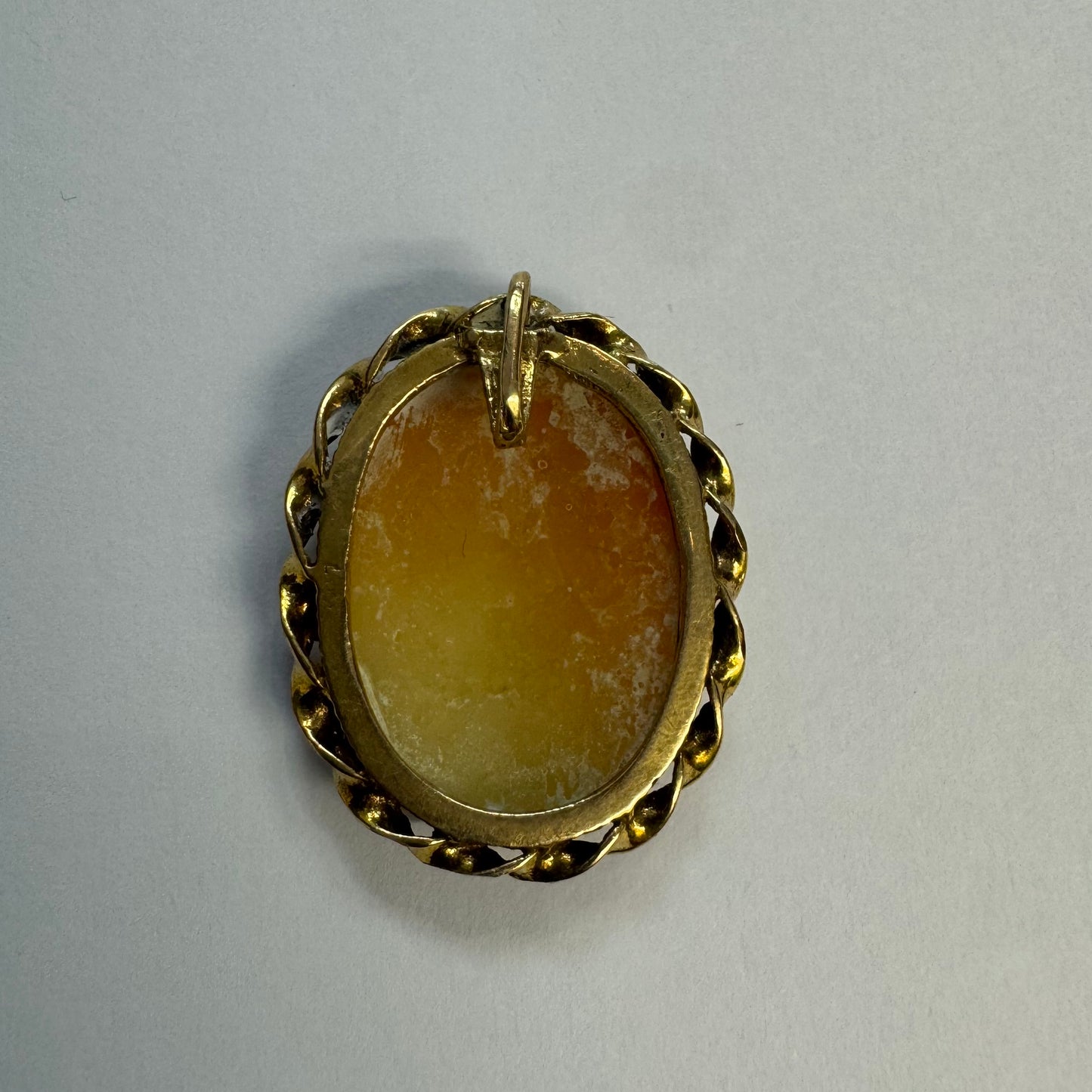 14K gold vintage cameo brooch featuring a hand-carved figure in a soft green tone, set in a classic decorative gold frame.