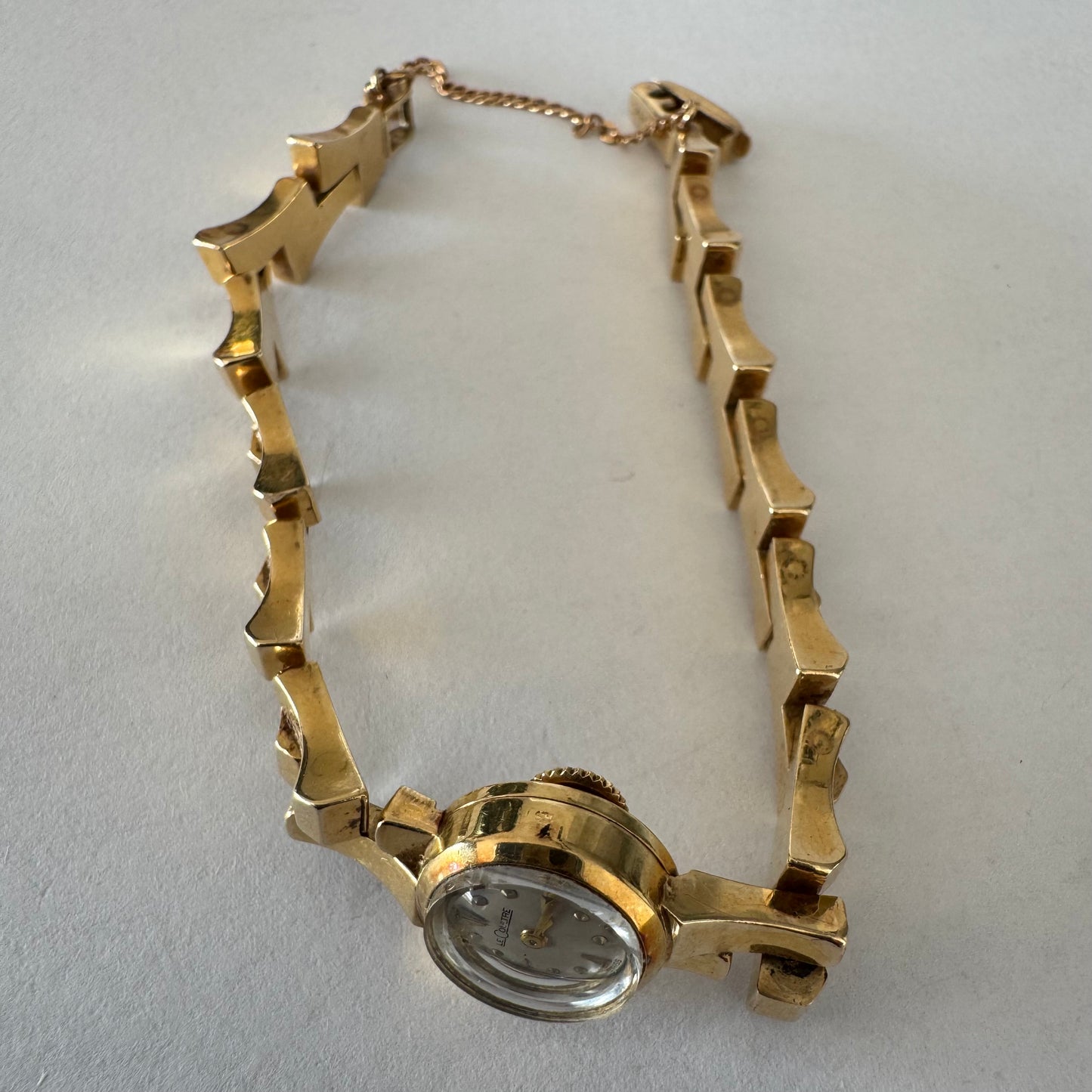שעון נשים של Jaeger-LeCoultre מזהב 18 קראט, בעל צמיד אינטגרלי בעיצוב פיסולי ולוח מחוגים מינימליסטי ואלגנטי.