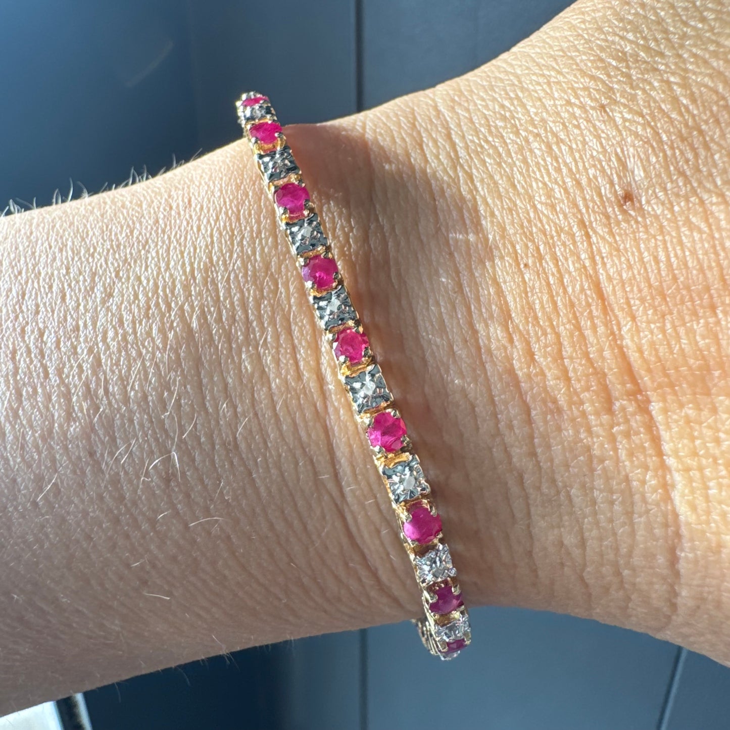 צמיד זהב צהוב 10 קראט משובץ אבני רובי בגוון אדום עמוק וביניהן יהלומים לבנים מנצנצים.