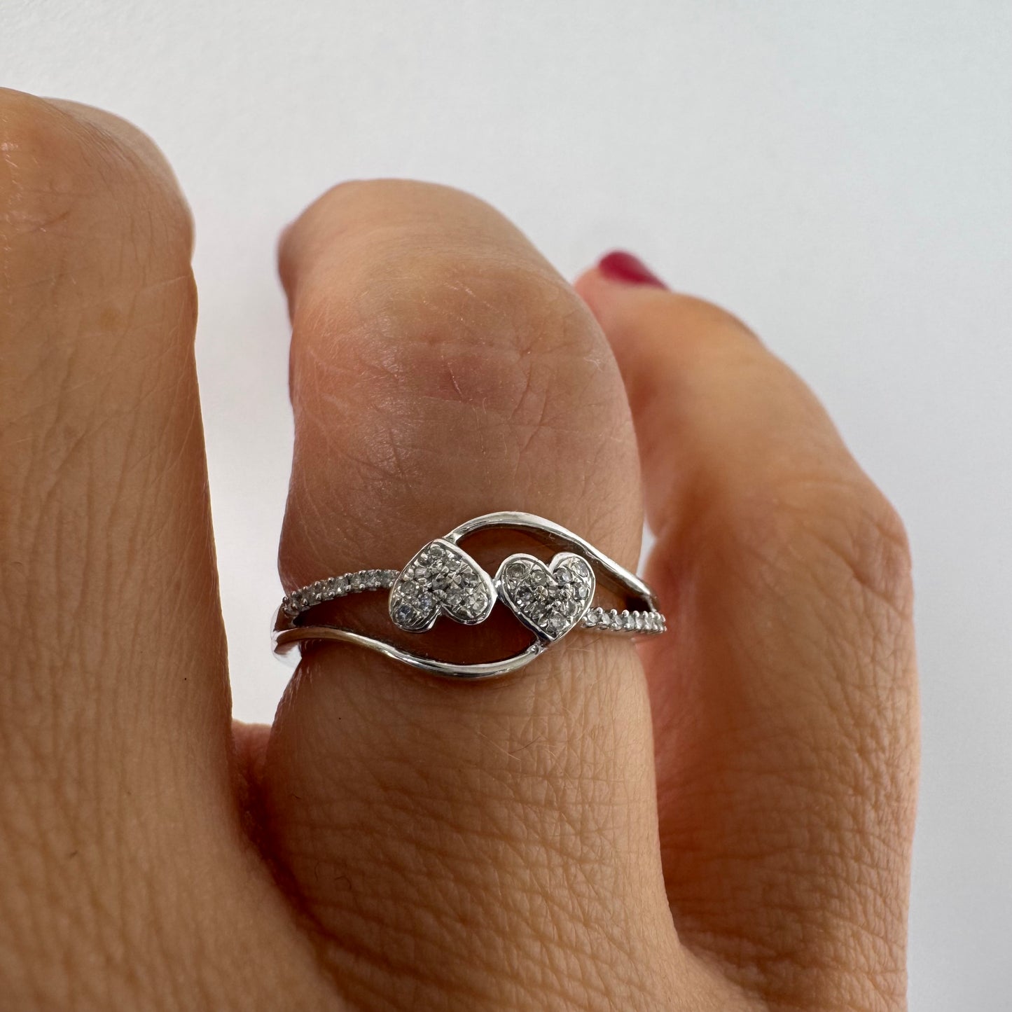 14K gold ring featuring a delicate and romantic design with two connected diamond hearts