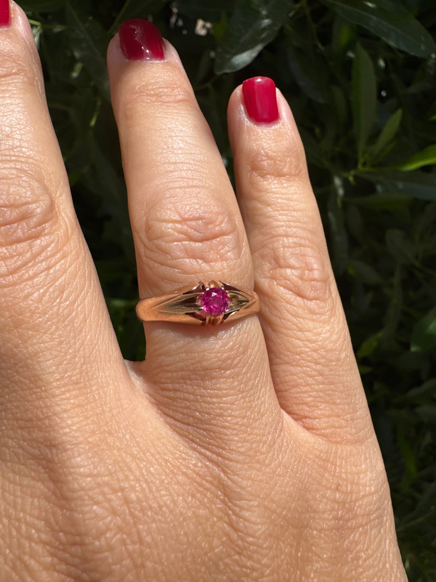 14K gold ring set with a vivid pink round-cut Ruby