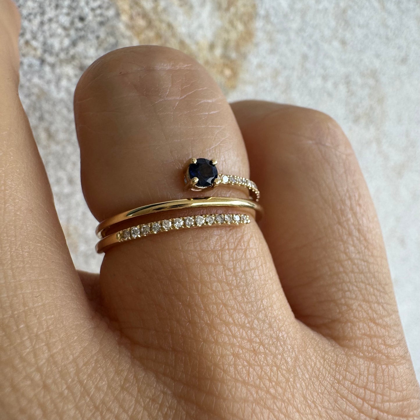 טבעת זהב צהוב 14 קראט משובצת אבן ספיר כחולה ויהלומים נוצצים בשורות עדינות.