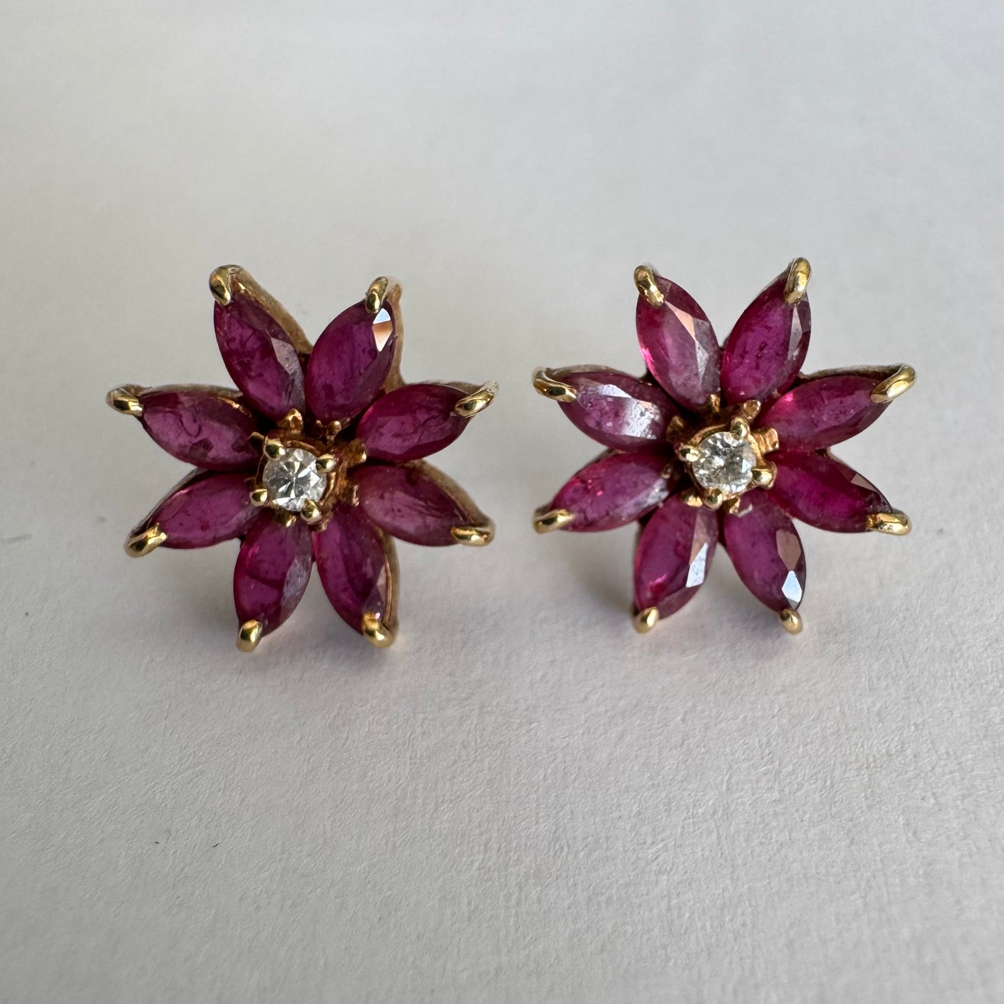 14K gold floral earrings set with marquise-cut Rubies and a small Diamond at the center