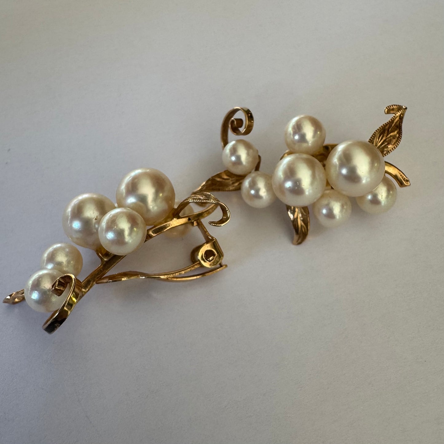 עגילי קליפס זהב 14 קראט, משובצים אשכול פנינים בגווני לבן-קרם.