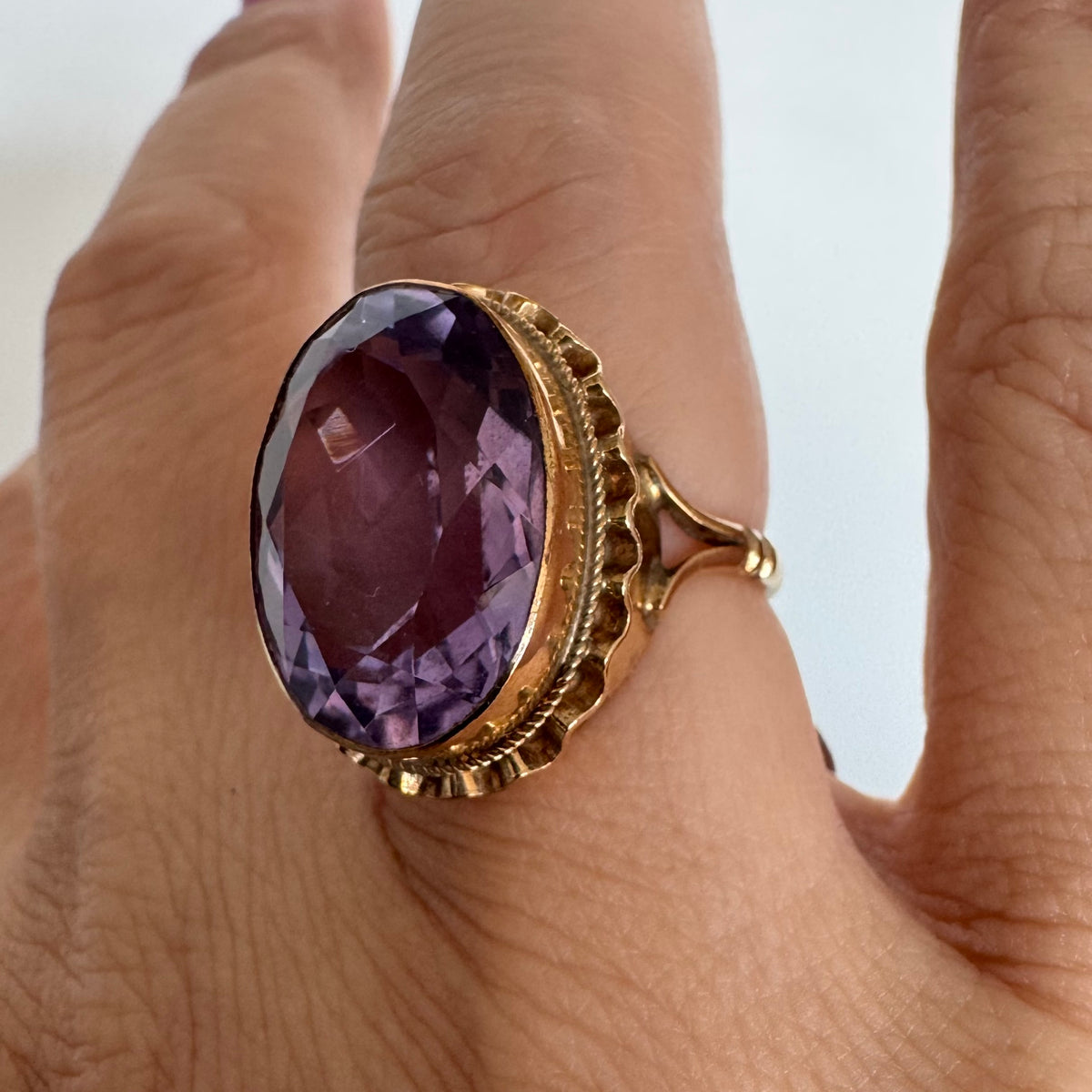 14K gold ring featuring a large oval-cut Amethyst set in an beautifully detailed gold setting