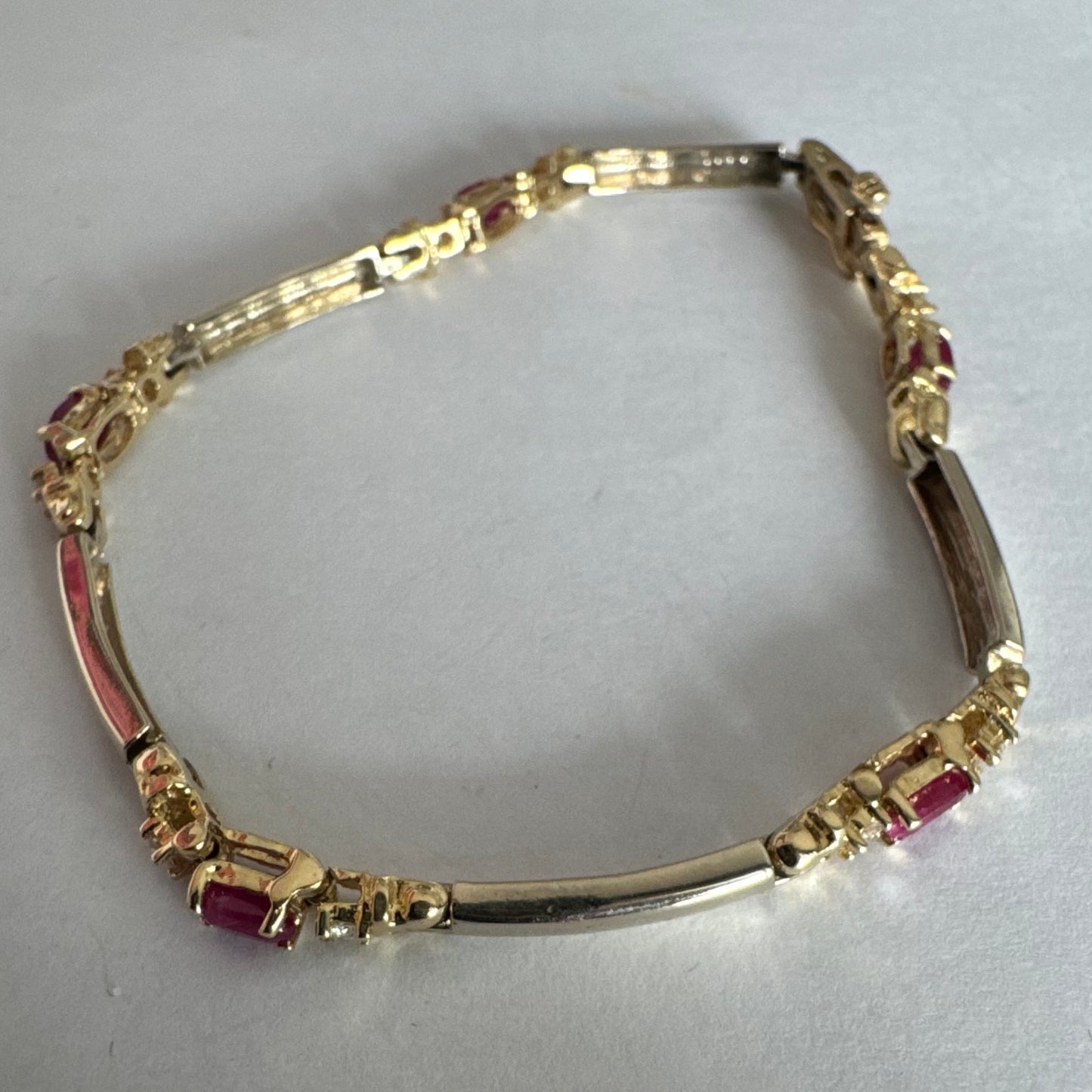 צמיד זהב צהוב 14 קראט משובץ אבני רובי אדומות בחיתוך אובלי, עם יהלומים המשובצים ביניהן להוספת ברק עדין.