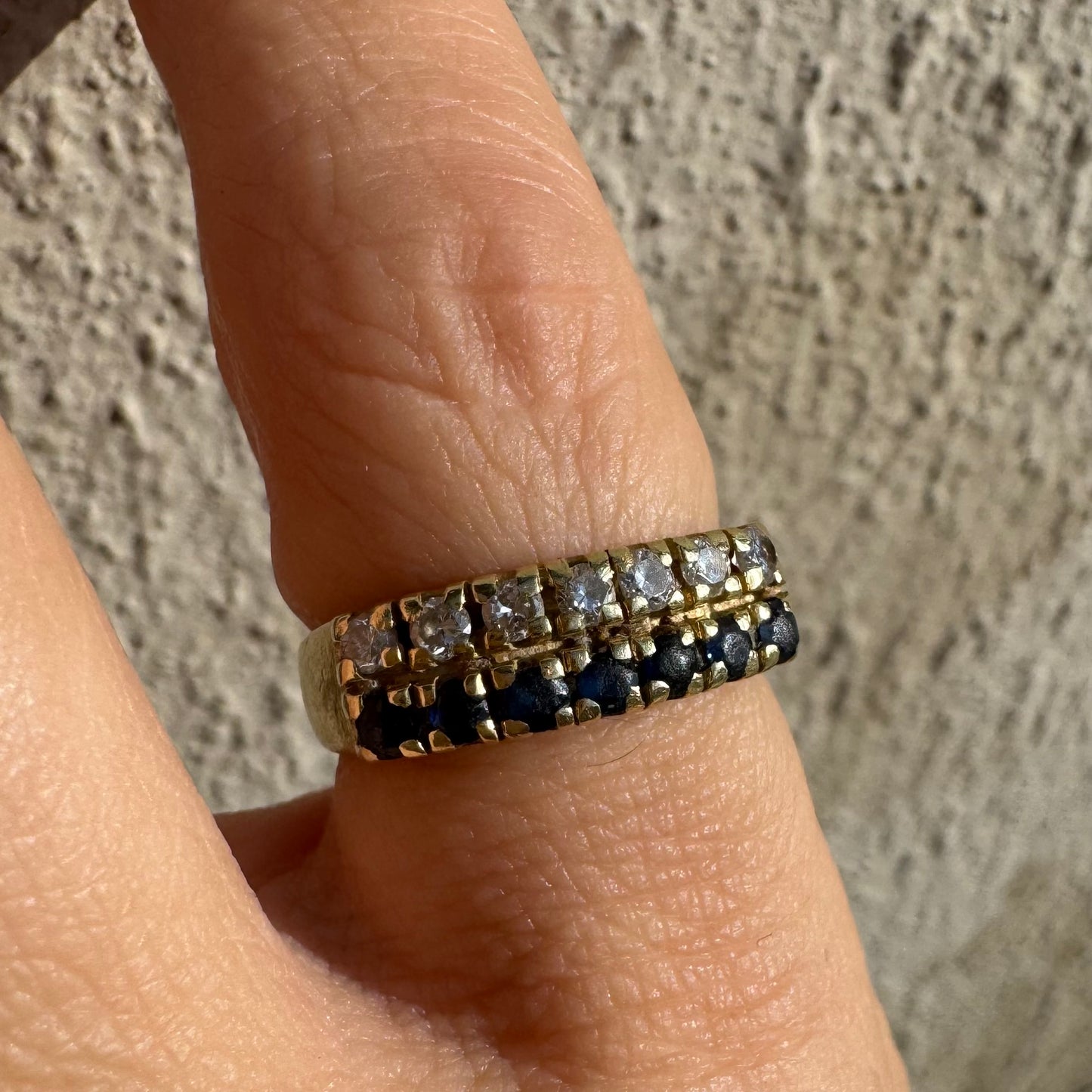 טבעת זהב צהוב 14 קראט, עם שורה של יהלומים נוצצים ושורה נוספת של ספירים כחולים.