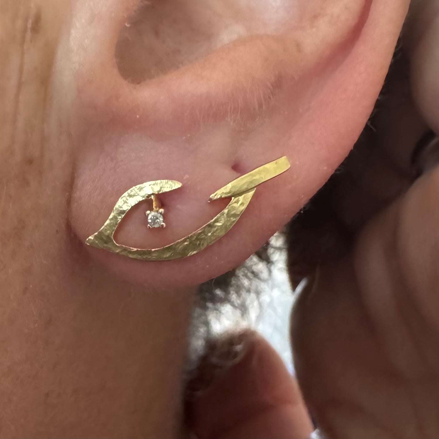 18K gold earrings in an abstract and elegant design featuring a unique handcrafted texture and a delicate Diamond set at the center
