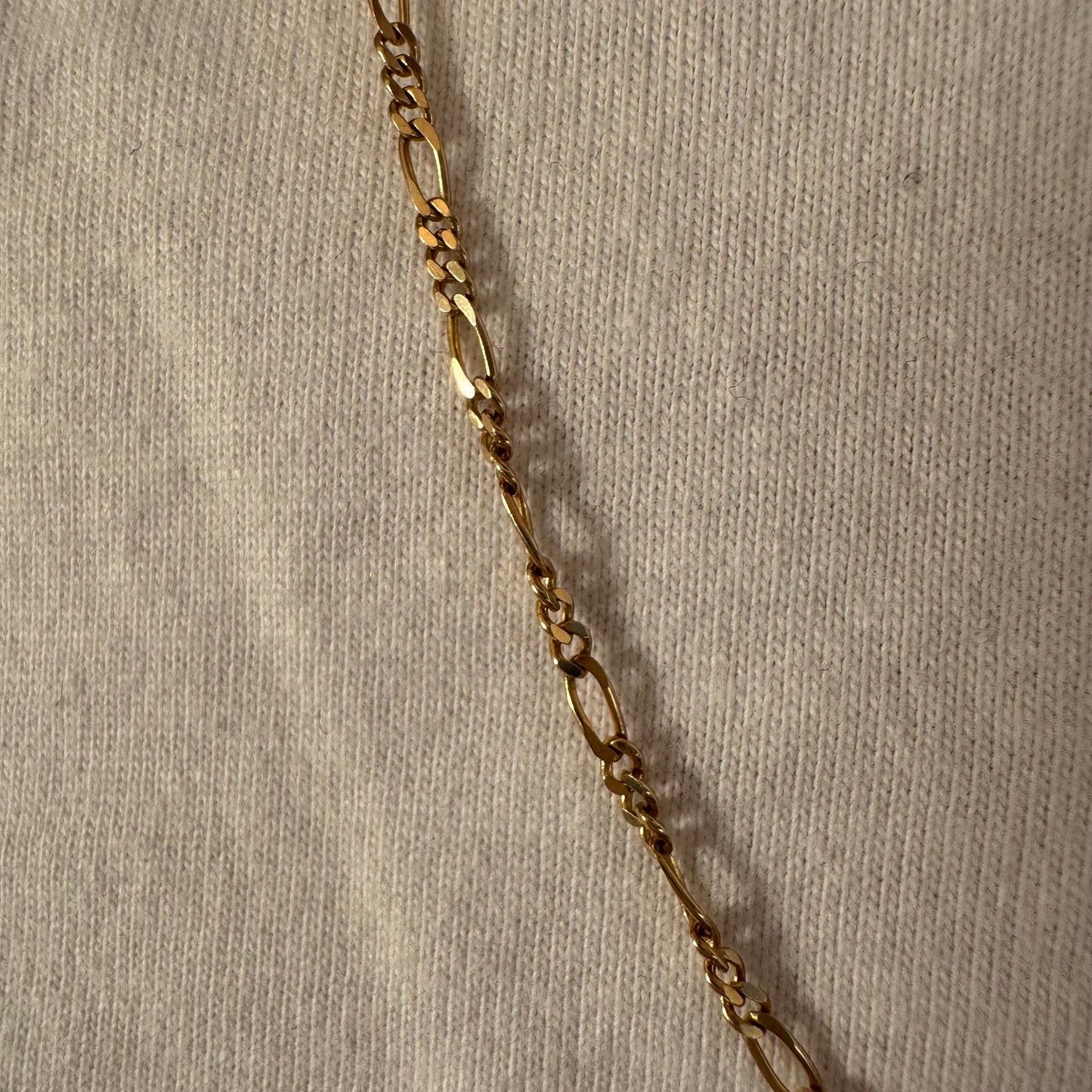 שרשרת זהב צהוב 14 קראט בעיצוב חוליות דקות ומוארכות עם טוויסט עדין שנותן לה מראה אלגנטי ונקי.