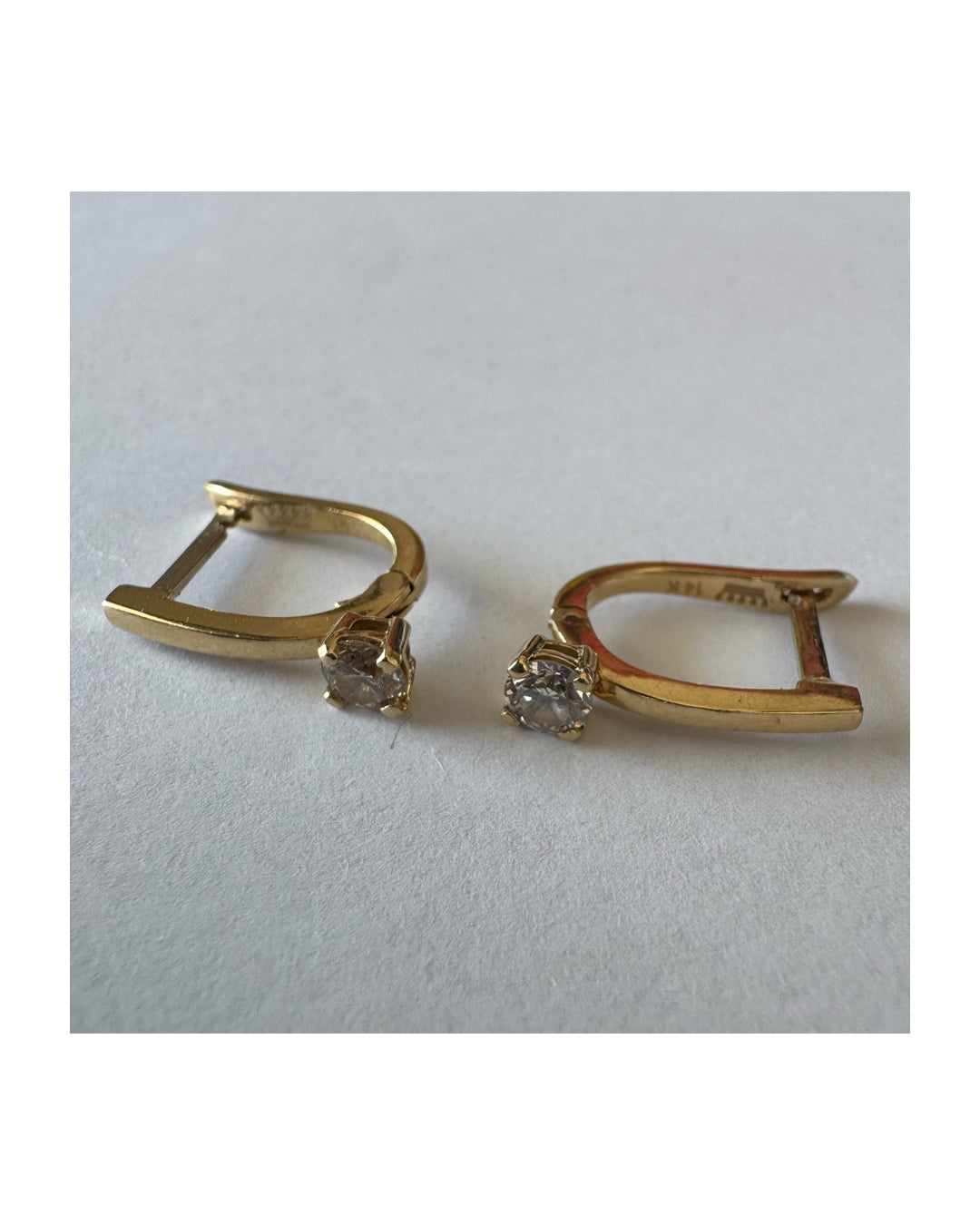 14K gold earrings set with round brilliant-cut Diamonds.